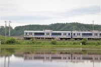 水が張られた田んぼを駆け抜ける列車。水面に反射しています。